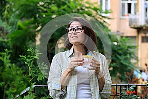 Mature woman drinking water with lemon. Natural antioxidant, diet drink