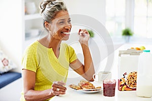 Mature Woman Eating Breakfast At Home photo