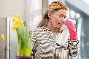 Mature woman with facial wrinkles feeling bad suffering from allergy