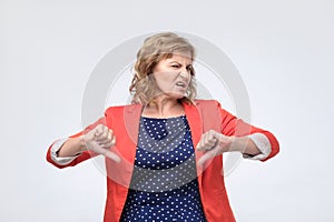 Mature woman giving a negative thumbs down gesture of disapproval