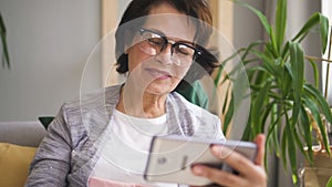 Mature woman in glasses, with brown hair having video