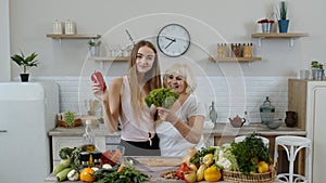 Mature woman with grandchild girl recommending eating raw vegetable food. World vegan day concept