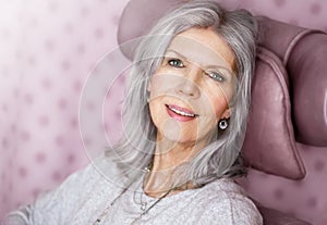Mature woman is happy to lounge in the armchair