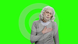 Mature woman having heart ache on green screen.