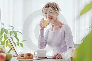 Mature woman having a relaxing breakfast at home