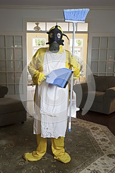 Mature woman in Haz Mat suit with blue broom and dust pan photo