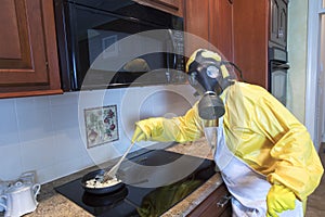 Mature woman in Haz Mat suit cooking photo