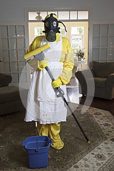 Mature woman in Haz Mat suit in living room with mop photo