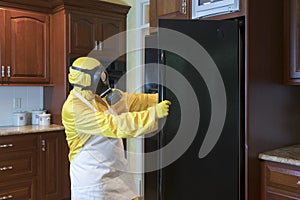 Mature woman in Haz Mat suit looking in refrigerator photo