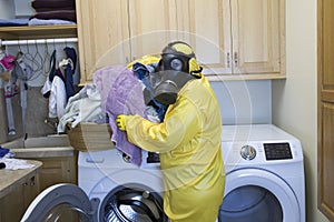 Mature woman in Haz Mat suit sorting laundry photo