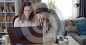 Mature woman helping her teenage daughter to do homework