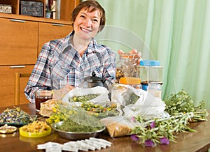 Mature woman with herbs at table