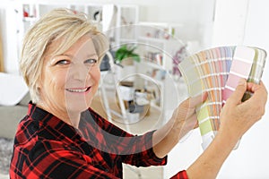 Mature woman holding color swatch