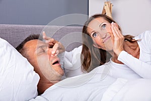 Mature Woman Holding Her Husband`s Nose