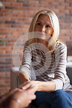 A mature woman holds the hands of her interlocutor. A moment of sympathy, closeness between older people. Forgiveness and Trust