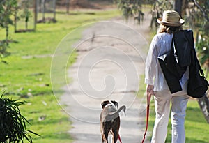 Mature woman on holiday walking pet dog