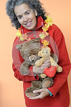 Mature woman hugging Teddy bears and a red heart.