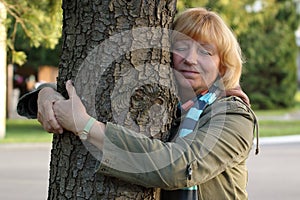 Mature woman hugging tree