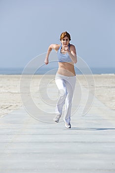 Mature woman jogging at the beach