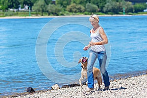 Mature woman jogs with a dog riverside