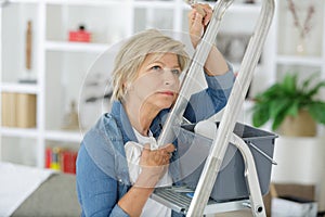 Mature woman looking daunted by redecorating job