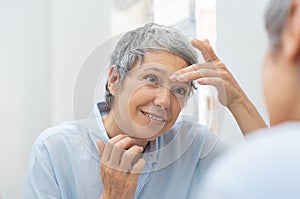 Mature woman looking her wrinkles face