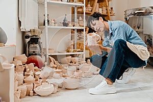 Woman looking at pottery handcrafts while sitting at the workshop