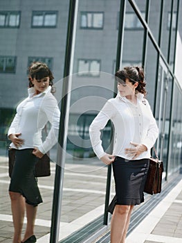 Mature Woman Losing Weight And Looking At Mirror In Office Window