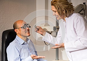 Mature woman and man retired ophthalmologist check eyesight in clinic