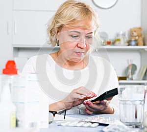 Mature woman with medicines and bills