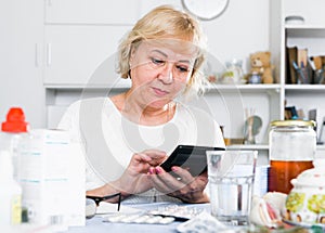 Mature woman with medicines and bills