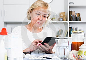 Mature woman with medicines and bills