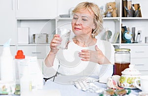 Mature woman with medicines and bills