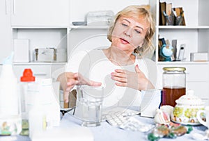 Mature woman with medicines and bills