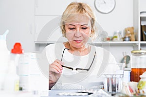 Mature woman with medicines and bills