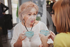 Mature woman meeting her senior mother at the coffee shop