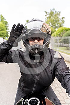 Mature woman in motorbiker clothing riding a modern motorcycle