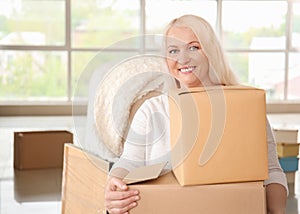 Mature woman with moving boxes at new home