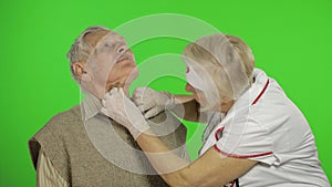 Mature woman nurse doctor examines senior patient man with problems