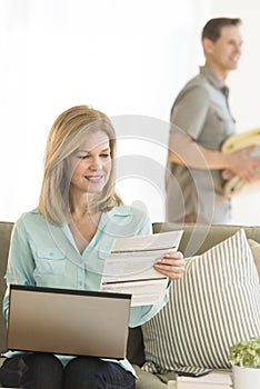 Mature Woman Paying Bills Using Laptop At Home