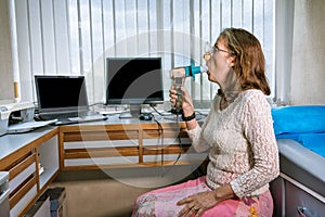 Mature woman performing pulmonary function test and spirometry