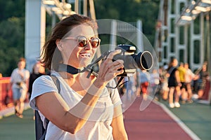 Mature woman photographer with camera taking photo picture