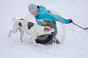 Mature woman playing with mixed breed dog hiding a rope