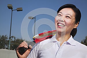 Mature woman playing tennis, portrait