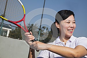 Mature woman playing tennis, portrait