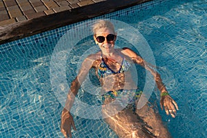 Mature woman in poolside, summer hot weather relax. Holidays in the pool. Swimming activity for healthy lifestyle