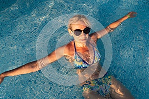 Mature woman in poolside, summer hot weather relax. Holidays in the pool. Swimming activity for healthy lifestyle