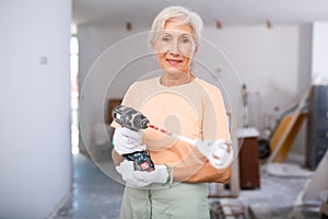 Mature woman posing with home renovation tools
