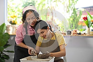 Zrelý žena hrnčiar výučba mladá žena sochárstvo riadu v dielňa. činnosť ručné práce záľuby 
