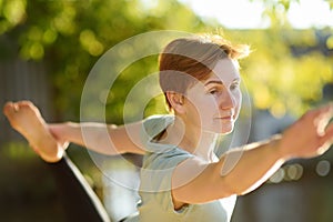 Mature woman practicing yoga outdoor exercise on the beach near the river